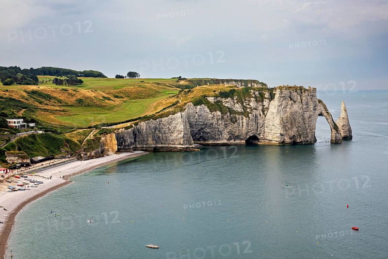 Famous cliff formation with grassy landscape and calm sea, The cliffs and alabaster coast of Etretat in Normandy France