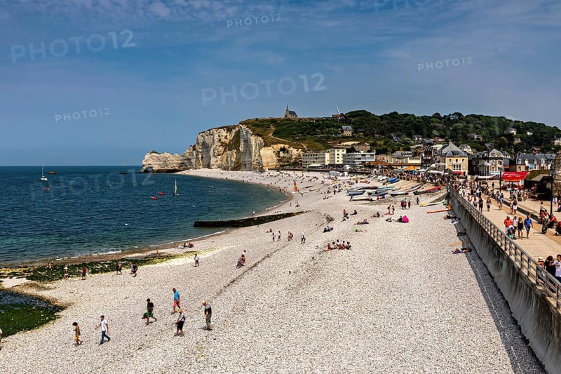 Coastal strip with beach and promenade, numerous walkers by the sea, Etretat in Normandy, France