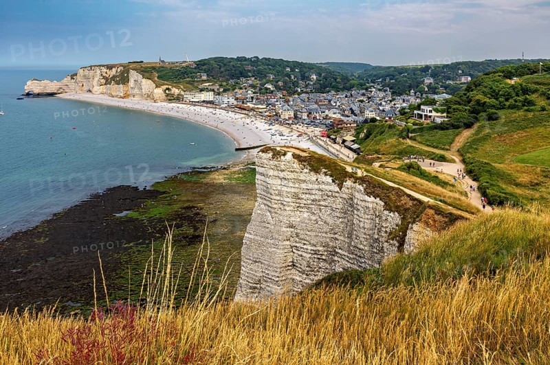 Landscape with high cliffs, meadows and a coastal town in the background, The cliffs and alabaster coast of Etretat in Normandy France