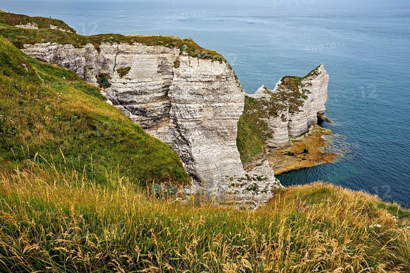 Rugged coastal terrain with impressive white cliffs and grass, The cliffs and alabaster coast of Etretat in Normandy France