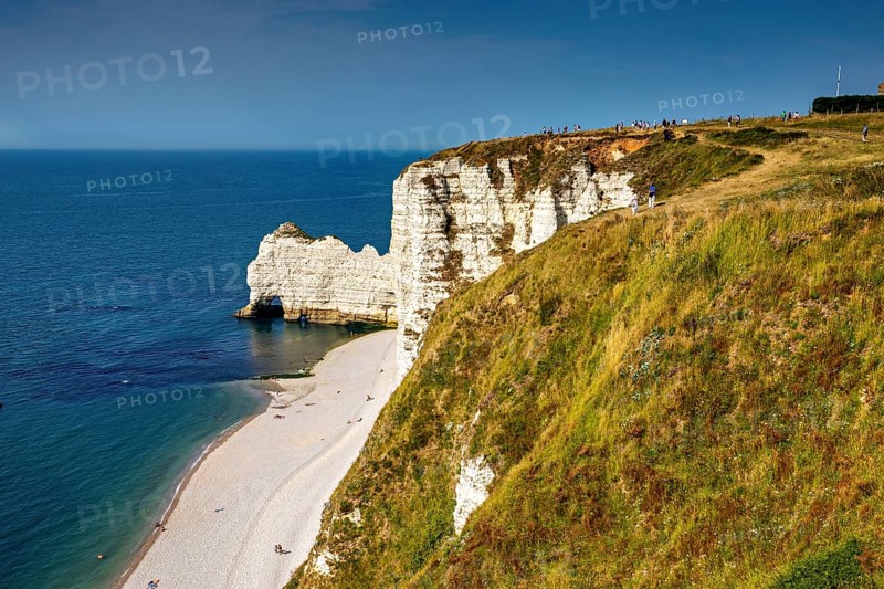 Panoramic view of the coastline with green cliffs and blue sea in sunny weather, The cliffs and alabaster coast of Etretat in Normandy France