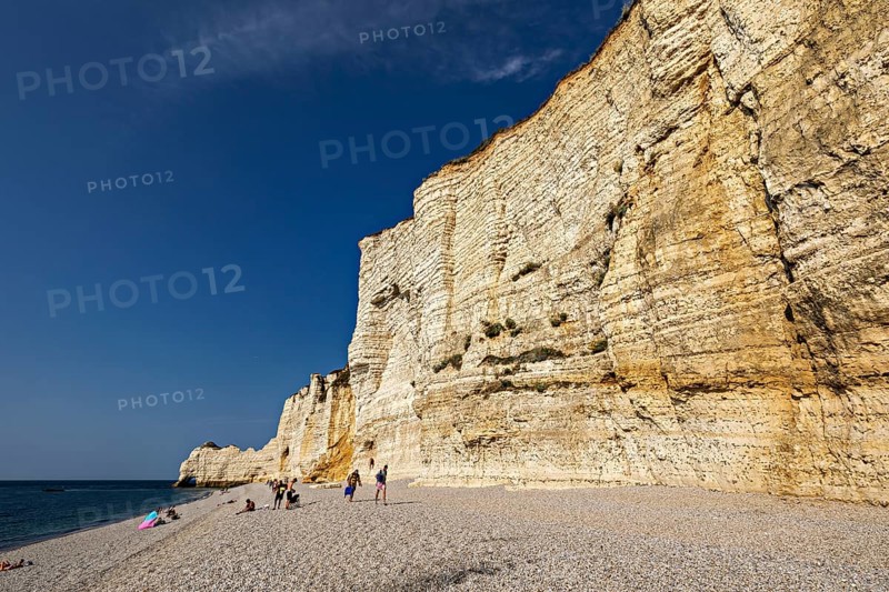 Endless beach, lined with impressive cliffs under a blue sky, The cliffs and alabaster coast of Etretat in Normandy France