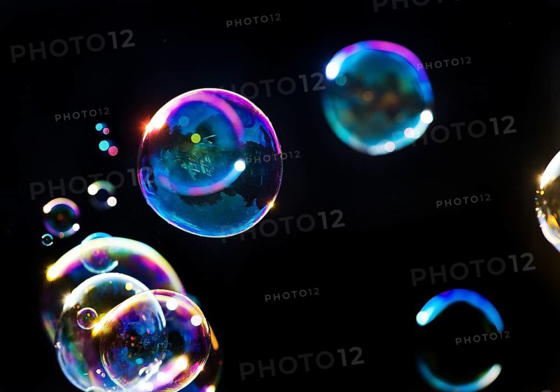 Iridescent soap bubbles in the colours of the rainbow against a black background, Recklinghausen, North Rhine-Westphalia, Germany