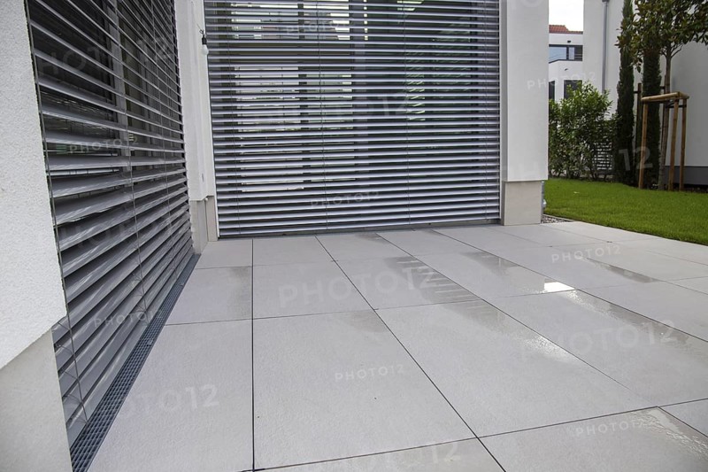 Modern terrace with large, light-coloured terrace tiles on a new detached house