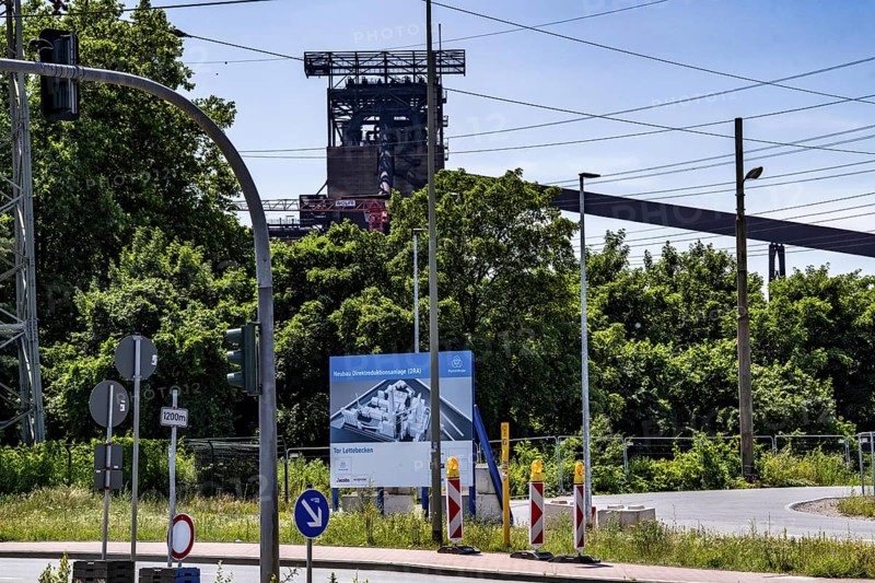Construction site sign for thyssenkrupp Steel's first direct reduction plant, the climate-neutral steel production project, at the existing steelworks in Duisburg-Farn, pig iron production without a conventional blast furnace but using hydrogen, due to go into operation by the end of 2027, North Rhine-Westphalia, Germany