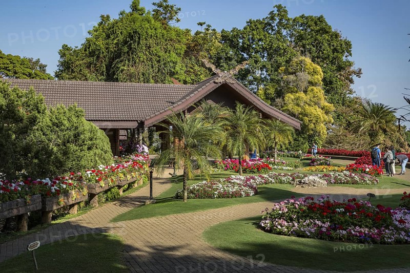 Ornate trees and lush flower gardens enhance the Lanna and Swiss architecture of the Doi Tung Royal Villa inside the Doi Tung tourist attraction in Chiang Rai, Thailand