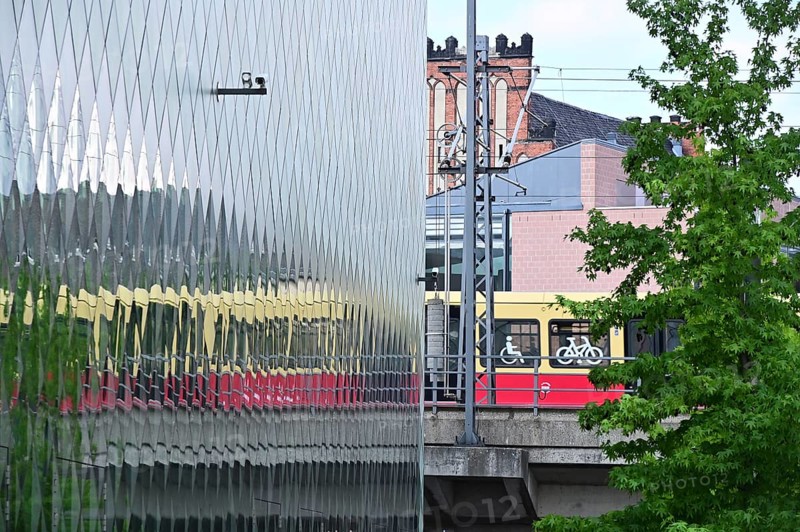 A suburban railway is reflected in the façade of the Futurium in Berlin-Mitte