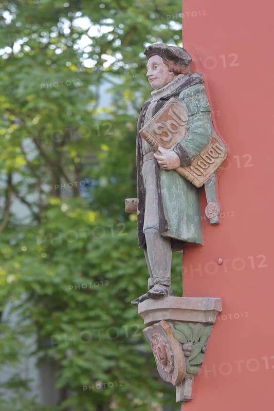 Historical merchant from the 16th century with book and inscription Soll Haben, created in 1933, symbol for order book, economy, orders, balance sheet, orders, economy, financial institution, bank, holding, carrying, under the arn, carrying, house corner, Halle an der Saale, Saxony-Anhalt, Germany