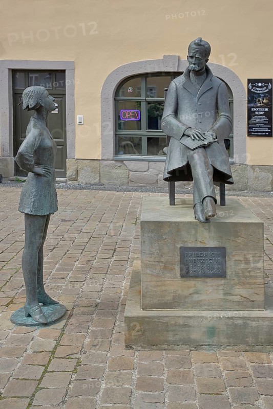 Monument to philosopher Friedrich Nietzsche, bronze sculpture, modern art, standing female figure, girl, sitting on chair, communication, conversation, listening, inscription, Holzmarkt, Saale, Naumburg, Saxony-Anhalt, Germany