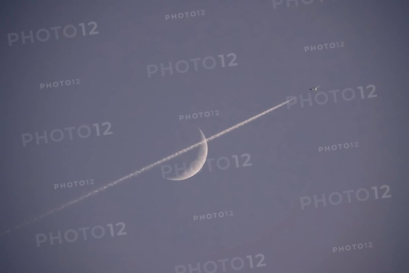 Evening sky with crescent moon and aeroplane, Germany