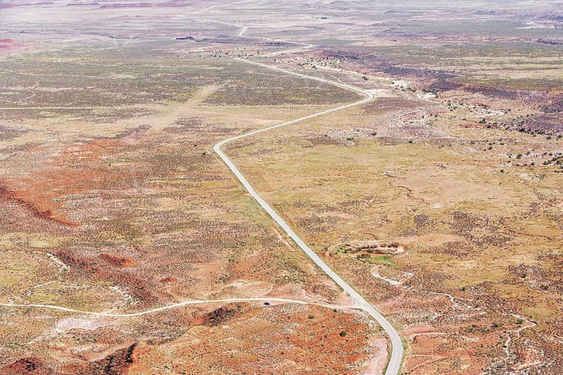 Winding roadway cutting through Valley of the Gods, Utah, USA