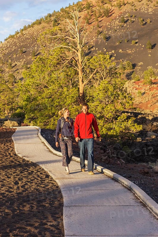 Couple walking on pathway, Sunset Crater Volcano National Monument, Flagstaff, Arizona, USA