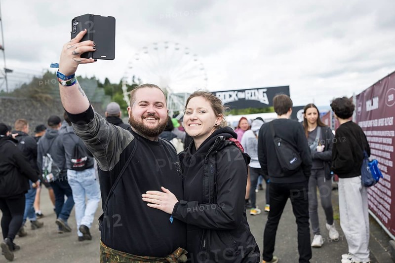Festival visitors Kevin and Jenny take a photo in front of a container with the Rock am Ring logo at the Rock am Ring Festival on Friday, Nürburgring race track race track, 06.06.2025