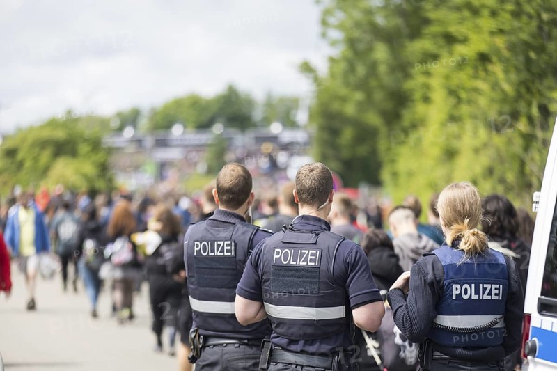 Police officers watch festival visitors on their way to the main entrance at the Rock am Ring Festival on Friday, Nürburgring race track race track, 06/06/2025