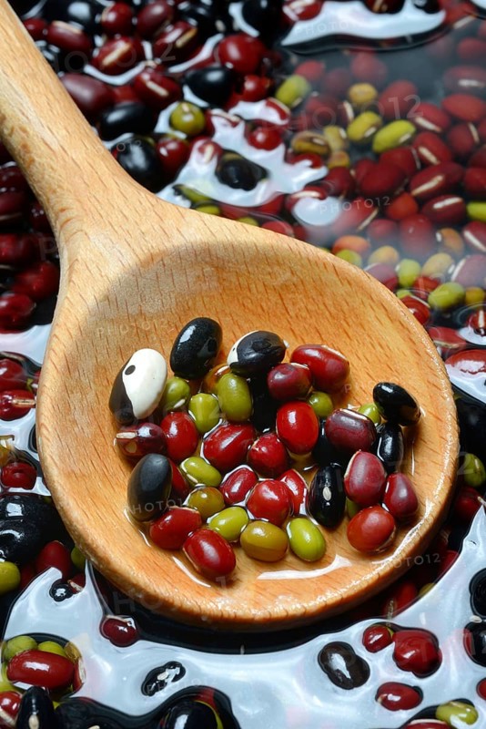 Dried beans placed in water to soak, wooden spoon