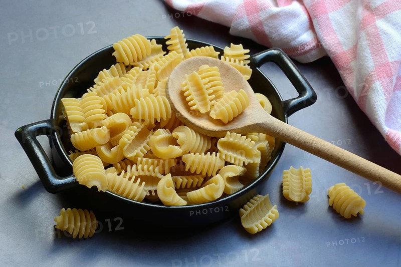 Italian pasta in pot with wooden spoon, Radiatori variety