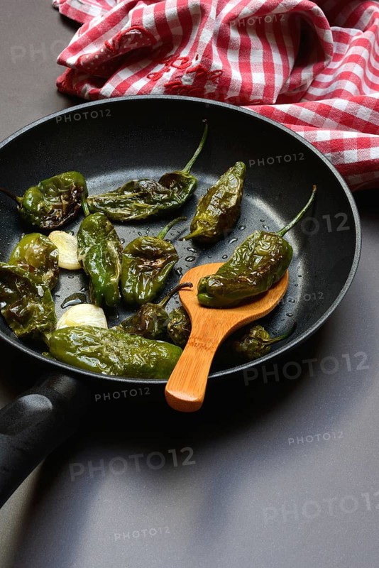 Pan-fried pimientos de padron in olive oil, roast peppers