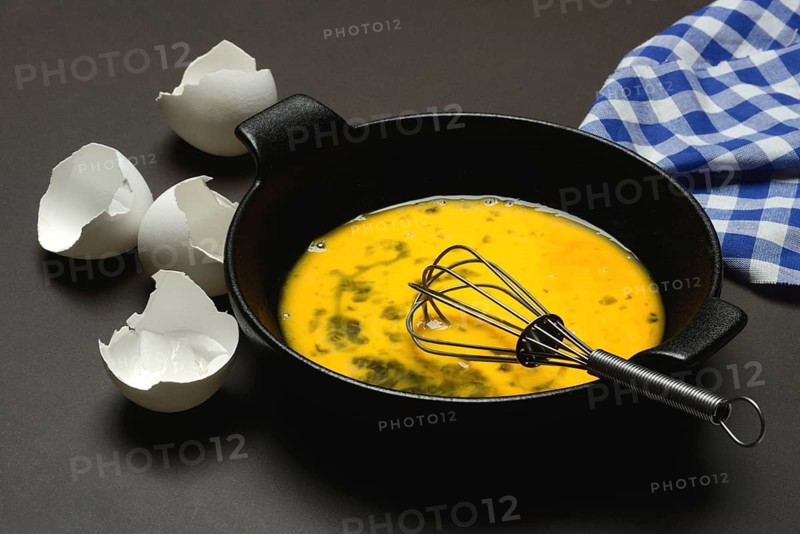 Cracked egg in a pan, hen's egg and eggshells