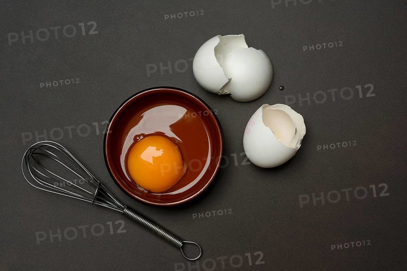 Whipped egg in small bowls, hen's egg and eggshells