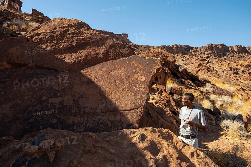 Tourist guide explains the details of the rock engravings at Twyfelfontein, Twyfelfontein, Kunene, Namibia
