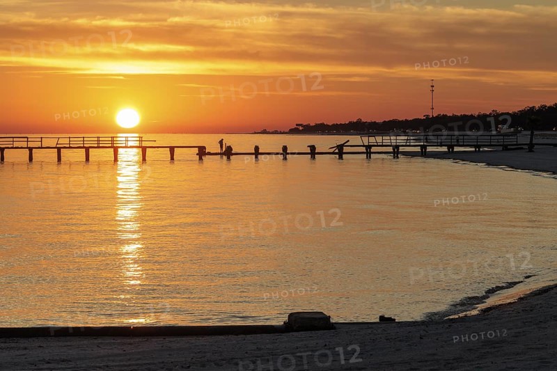 Sunset behind dilapidated fishing pier damaged by hurricanes on the Mississippi Gulf Coast in Long Beach, Mississippi