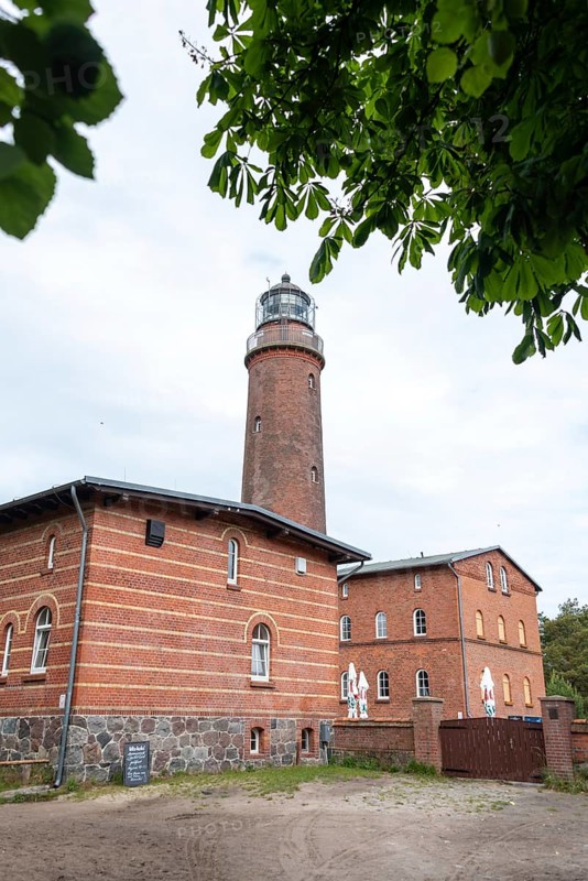 Lighthouse Darßer Ort, brick lighthouse next to a historic building, surrounded by trees under a cloudy sky, Prerow, Mecklenburg-Vorpommern, Germany