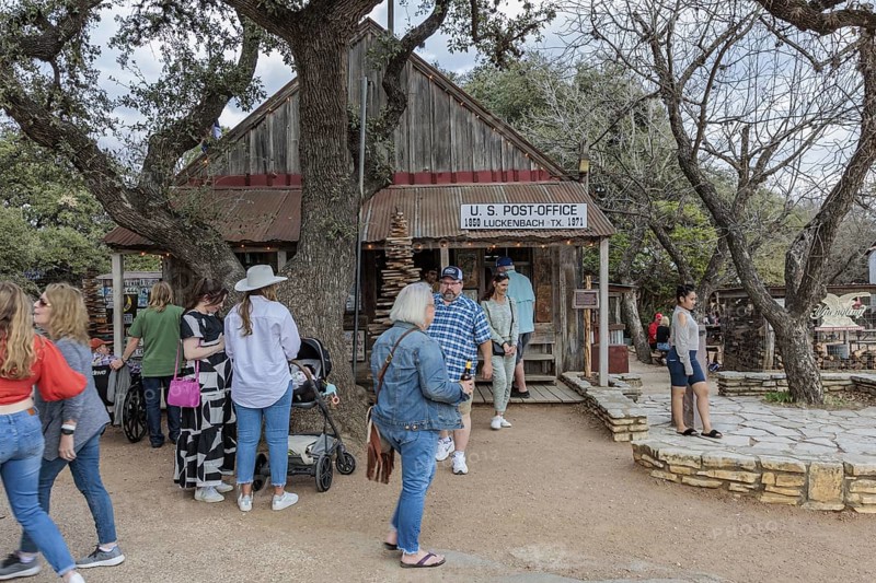 Tourists mingle outside the US post office in Luckenbach, Texas, USA