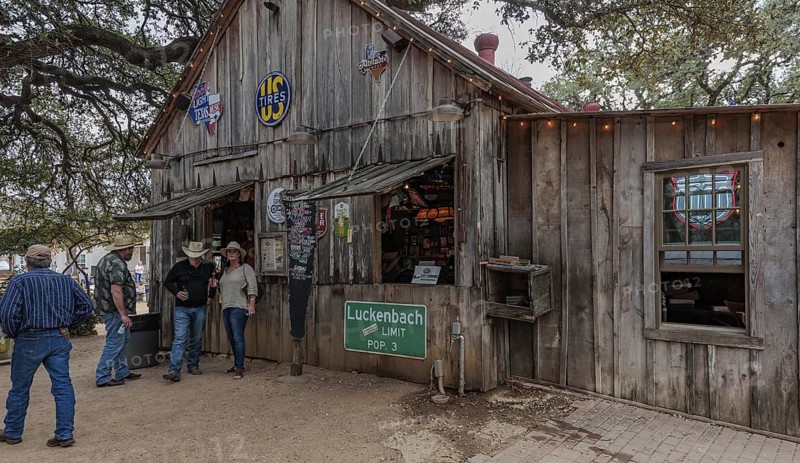 Tourists drinking beer at an open-air bar in Luckenbach, Texas, USA