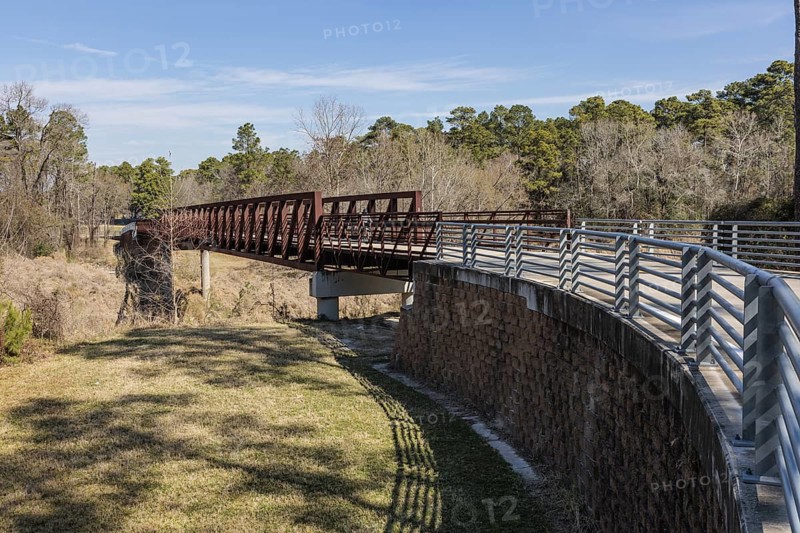 Steel bridge along paved biking and walking trail in Cypress Creek Park at Timber Lane in Spring, Texas, USA