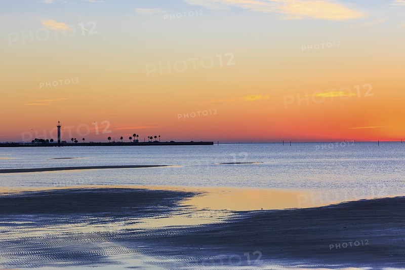 Sunrise silhouette of Broadwater Beach Marina Light at Biloxi, Mississippi, USA