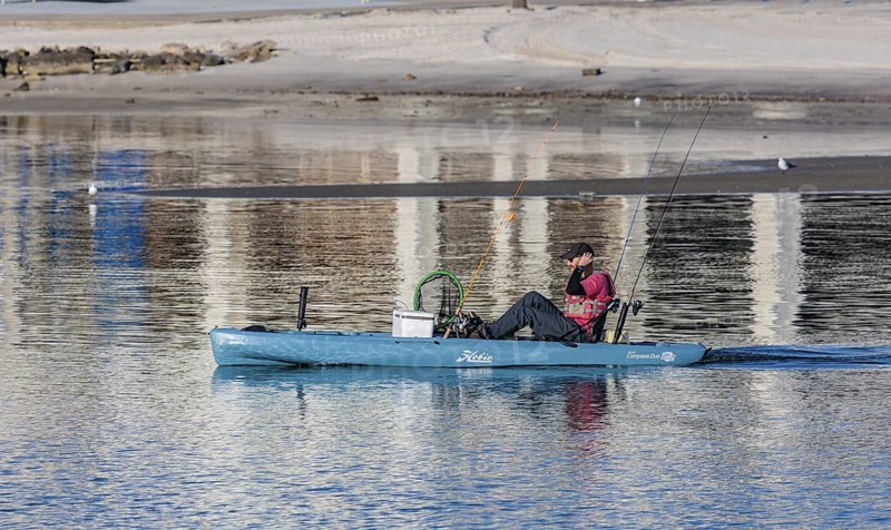 Man in Hobie kayak heads into the Gulf of Mexico for fishing at Gulfport, Mississippi, USA
