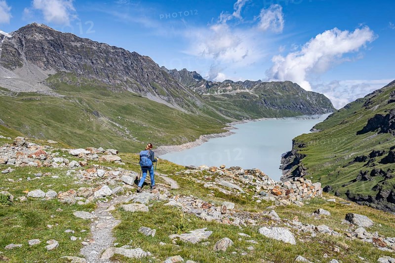 Mountaineer on a hiking trail in an idyllic mountain landscape, Lac des Dix reservoir in the background, Valais Alps, Valais, Switzerland
