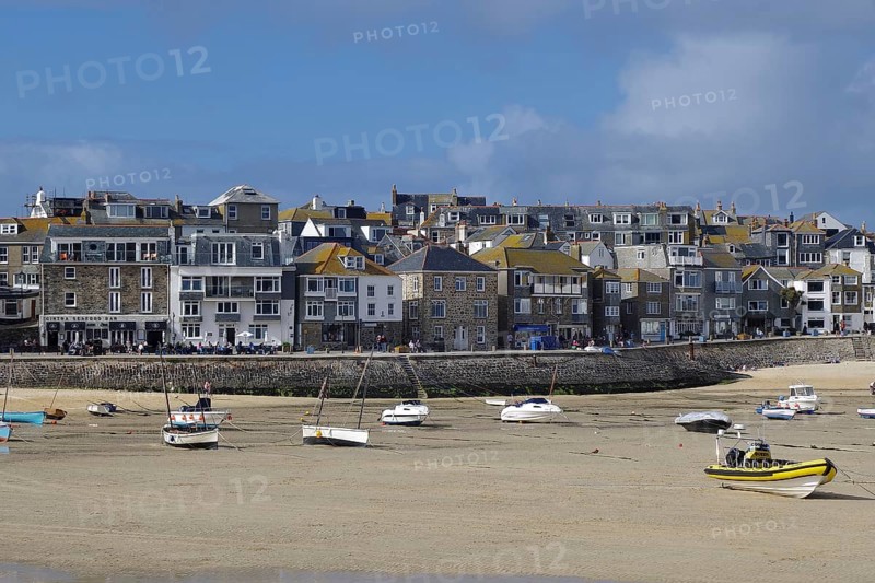 A busy coastal harbour with many boats and a town with densely built houses, St Ives, Cornwall, England, United Kingdom