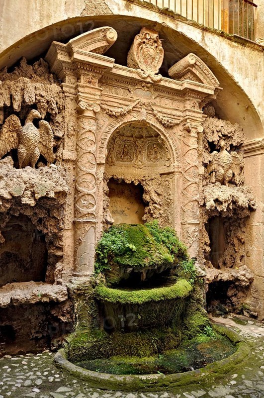 Ornamental fountain from the Renaissance, fountain with moss and artificial dripstone from the Mannerist period, courtyard of Palazzo Conti, historic centre, Poli, Monti Prenestini, metropolitan city of Rome, Lazio, Italy