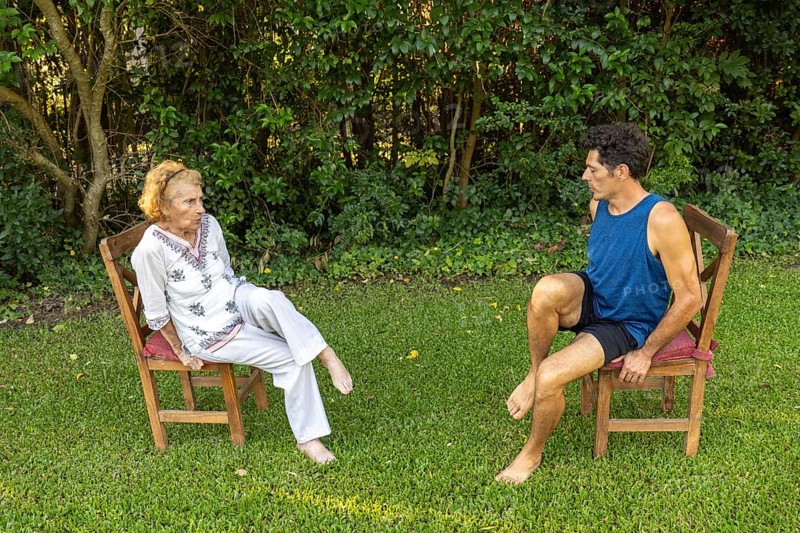 Physiotherapist guides a senior woman through gentle rehabilitation exercises, focusing on mobility and strength training in a peaceful outdoor setting