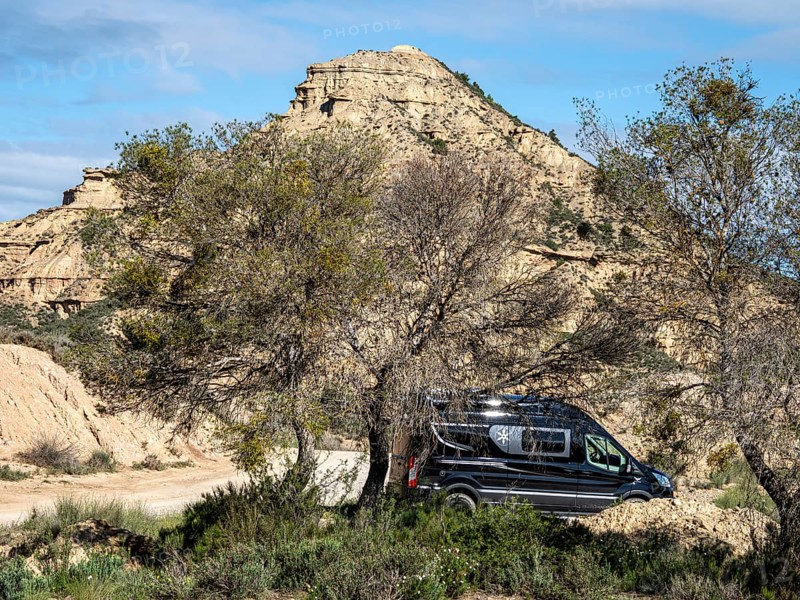 Camper van, gravel road Ruta Jubierre, desert, rock formations, Desierto de los Monegros, Spain