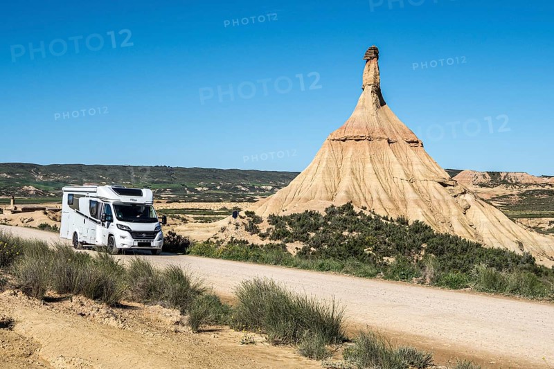 Camper van on gravel road, Castildetierra rock formation, semi-desert, Bardena Blanca area, Bardenas Reales Nature Park, Navarre, Spain