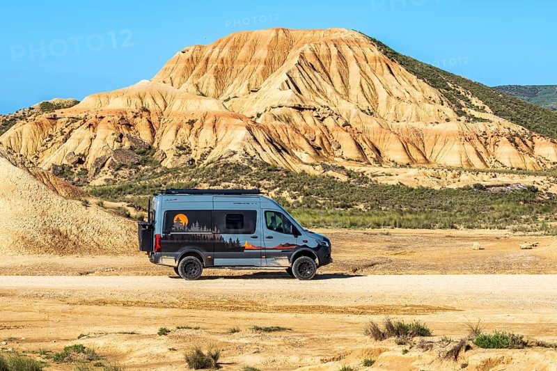 Camper van, colorful rock formation, semi-desert, Bardena Blanca area, Bardenas Reales Nature Park, Navarre, Spain
