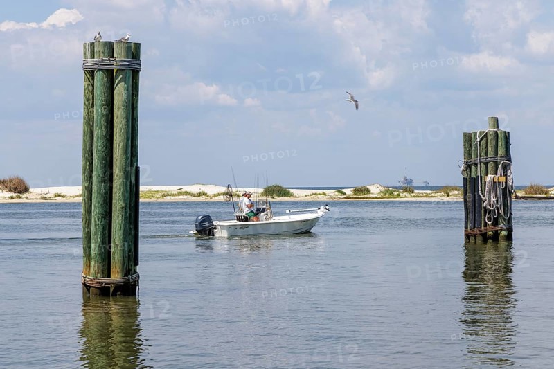 Two men on a fishing boat in Mobile Bay along the coast of Dauphin Island in Alabama