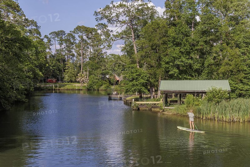 Young woman paddleboarding on the Magnolia River in Magnolia Springs, Alabama