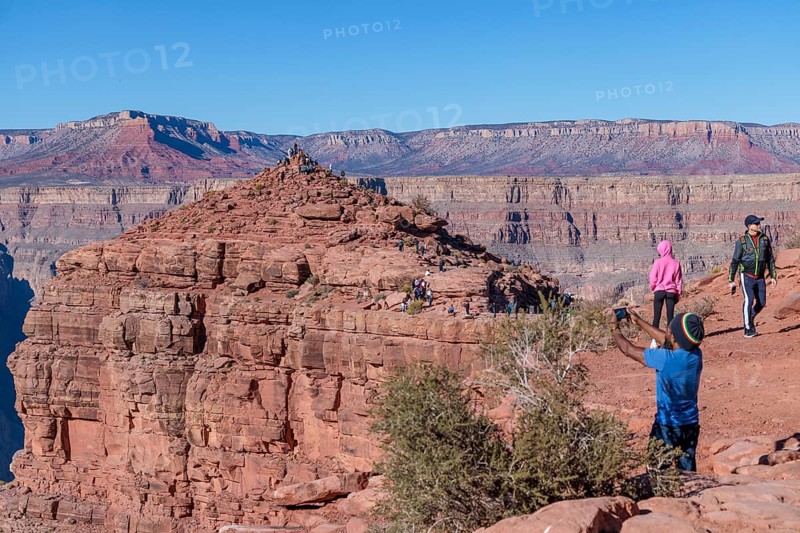 Visitors climb on rock formation rising above the canyon at Guano Point in Grand Canyon West near Peach Springs, Arizona