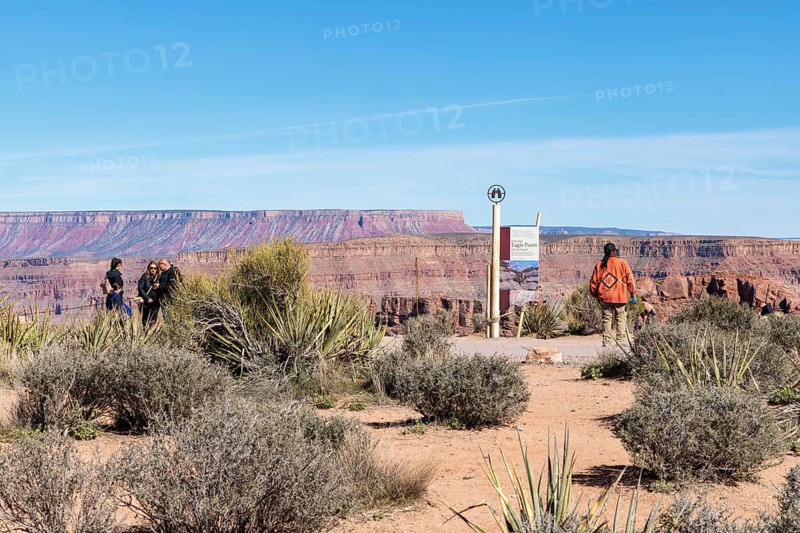 Native American security officer standing by sign with information about Eagle Point observation area at Grand Canyon West near Peach Springs, Arizona