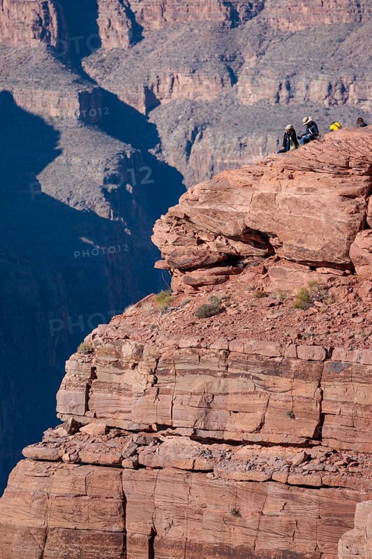Visitors climb on rock formation rising above the canyon at Guano Point in Grand Canyon West near Peach Springs, Arizona