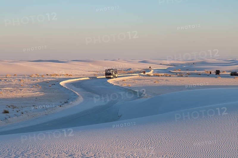 Motorhome being driven on cleared road through the white gypsum dunes at White Sands National Park in Alamogordo, New Mexico, USA