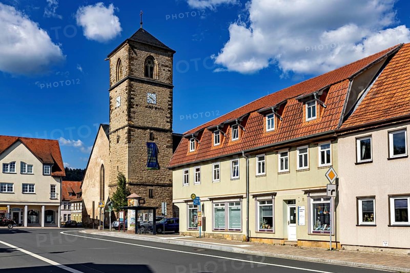 Church tower next to village buildings under a cloudy blue sky, The steeple of the Protestant church of Creuzburg in Thuringia