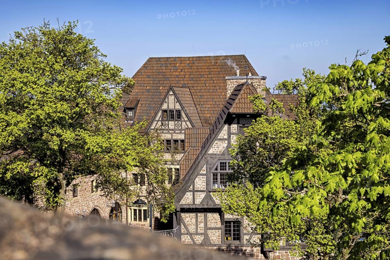 Half-timbered house surrounded by trees on a sunny day with a blue sky, The Hotel zur Wartburg near Eisenach in Thuringia