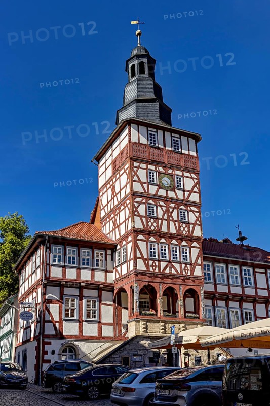 Half-timbered tower with clock surrounded by historic buildings and parked cars on a clear day, The town hall of Treffurt in Thuringia