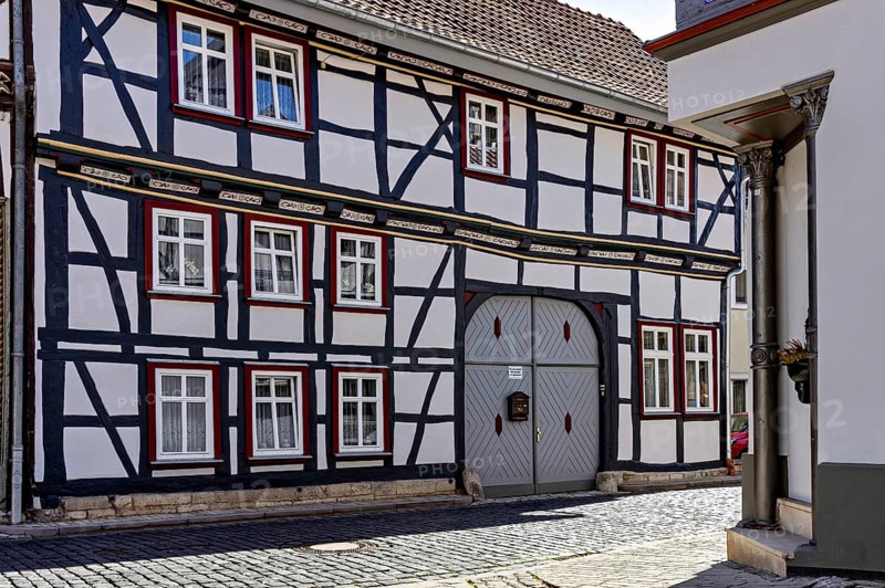 A traditional half-timbered house with a characteristic wooden structure and small windows in a cobbled alley, Historic half-timbered houses in the town of Treffurt in Thuringia