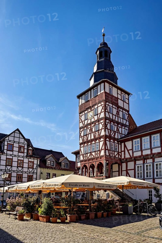Historic half-timbered building with tower and sunshades on a market square under a clear blue sky, The town hall of Treffurt in Thuringia