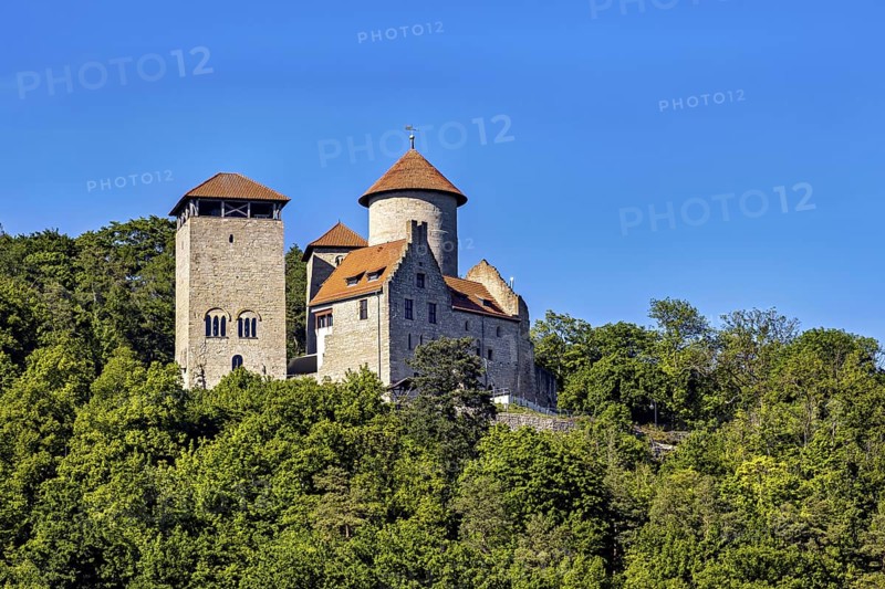 Historic castle in summer with recognisable watchtower, nestled in a forest landscape under a blue sky, Normannstein Castle near Treffurt in Thuringia